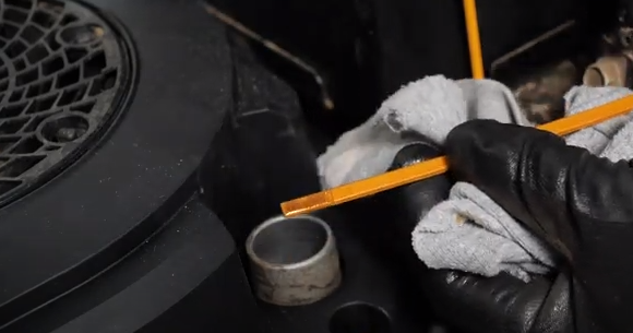 Using the dipstick to check the oil level.