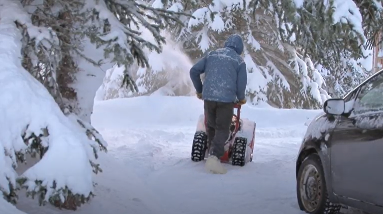 Person snowblowing driveway