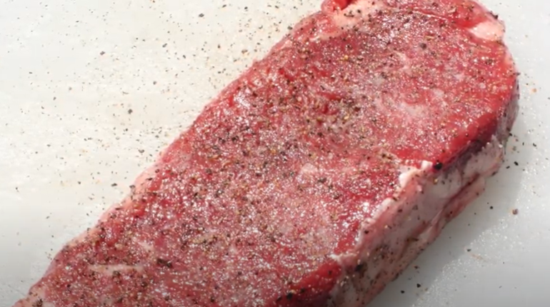Season steak with salt and pepper